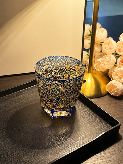 Cobalt blue Edo Kiriko crystal tumbler on black wooden tray by warm lamp